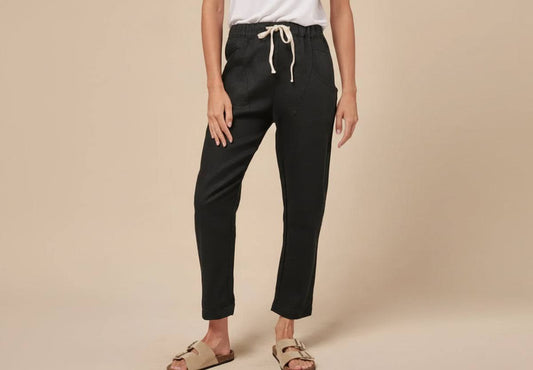 Little Lies Luxe Linen Pant in black, 100% linen with elastic tie waist and slim ankle-length leg, styled for coastal summer
